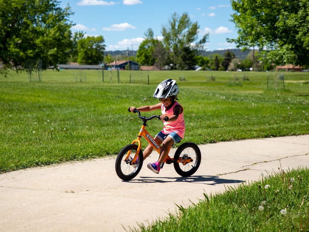Child learning to ride a Strider balance bike